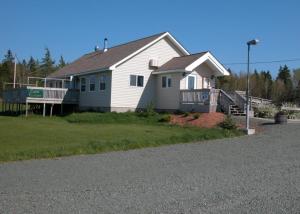 a white house with a porch and a driveway at Waterview B&B in Pictou
