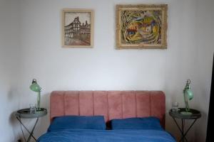 un letto con testiera rosa e due tavoli con lampade di Comfy 1-Bed Flat Near Hospital & Station a Londra