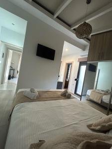 a bedroom with a large bed and a tv on the wall at Ivory Style Maisonette near Downtown in Heraklio Town