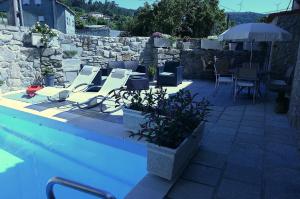 a pool with chairs and tables and an umbrella at Pedras Vellas in Coaxe