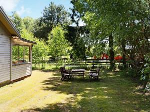 una mesa y sillas en un patio junto a una casa en 5 person holiday home in Skummeslövsstrand, en Skummeslövsstrand