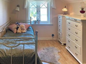 a bedroom with a bed with a teddy bear on it at 4 star holiday home in TJÖRN in Almösund