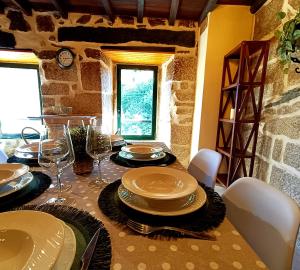 a table with plates and wine glasses on it at Luz do Sil in Ourense
