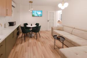 a living room with a couch and a table and chairs at Atelier 51 - Free parking in Mostar