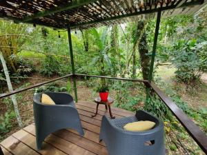 parawan na werandzie z dwoma krzesłami i stołem w obiekcie Toucan Hideout with Plunge Pool w mieście Puerto Viejo +1 zdjęcie