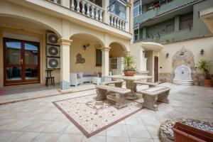 un patio con tavolo e panche in un edificio di La Casa di Tonina a Quartu SantʼElena