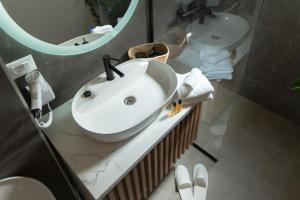 a bathroom with a white sink and a mirror at Atelier 51 - Free parking in Mostar +7 photos