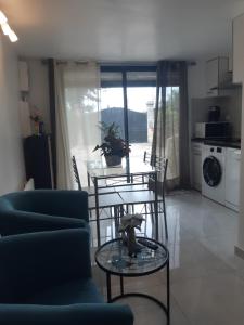 a living room with a table and chairs and a kitchen at Maison au calme 2 Chambre in Montgeron