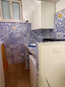 卡塔尼亚Sweet Home Catania historic center的厨房的墙壁上铺有蓝色和白色的瓷砖。