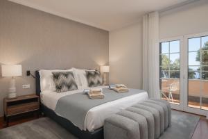 sypialnia z dużym łóżkiem i dużym oknem w obiekcie Exceptional luxury villa in Madeira Bellissima w mieście Estreito da Calheta +46 zdjęć