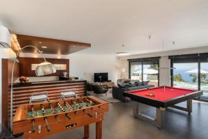 salon ze stołem do ping ponga i salonem w obiekcie Exceptional luxury villa in Madeira Bellissima w mieście Estreito da Calheta