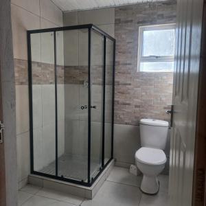 a bathroom with a shower with a toilet and a window at The Rehoboth in Dundee