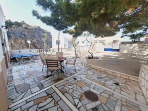 a stone patio with a table and chairs on it at Zoes House in Kyra Panagia