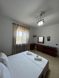 a bedroom with a large white bed and a window at Villa Bordeaux in Rrashbull