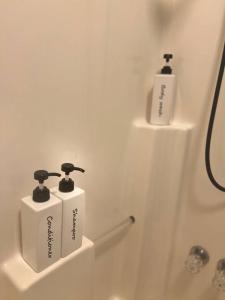 two bottles of soap sitting on the side of a bath tub at Quaint City Cottage Bremen, Ga in Bremen +36 photos