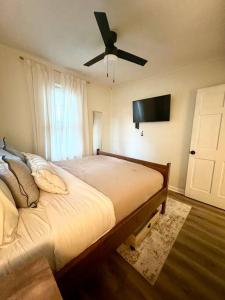 a bedroom with a large bed with a ceiling fan at Quaint City Cottage Bremen, Ga in Bremen