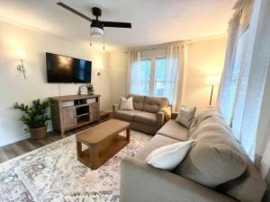 a living room with a couch and a flat screen tv at Quaint City Cottage Bremen, Ga in Bremen