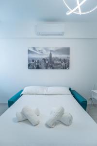 a bedroom with a white bed with a picture on the wall at Carlo's FN66 - nel Cuore di Sanremo - in Sanremo
