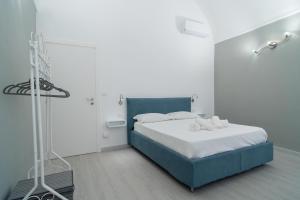 a bedroom with a blue bed in a white room at Carlo's FN66 - nel Cuore di Sanremo - in Sanremo
