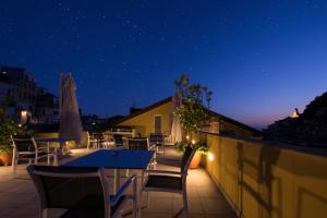 a patio with tables and chairs at night at Amalfi Luxury House in Amalfi
