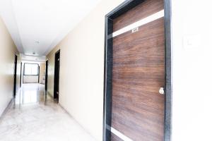 a wooden door in a hallway of a house at Capital O SKY GRAND in Hyderabad +49 photos