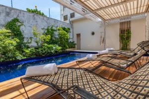 a patio with two chairs and a swimming pool at Nueva Apartasuite pleno centro in Santa Marta
