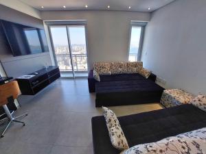 Una sala de estar con un sofá y un televisor. en Book Santos - Unlimited 3403 - A Melhor Vista no 34º andar!, en Santos