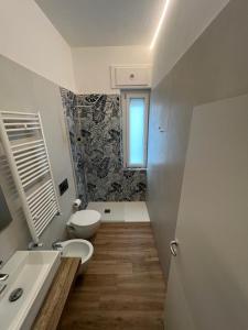 un bagno con un water, un lavandino e uno specchio di Gabriellihome a Pescara