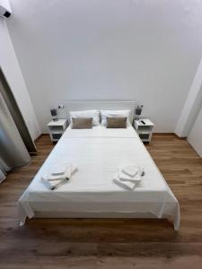 un letto bianco in una stanza con due tavoli di Gabriellihome a Pescara