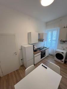 una cucina con frigorifero bianco, tavolo e sedie di Gabriellihome a Pescara