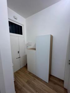 una stanza vuota con un frigorifero bianco e una finestra di Gabriellihome a Pescara