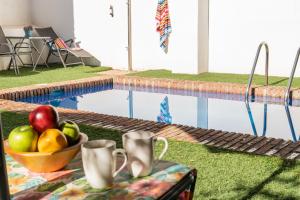 a bowl of fruit on a table next to a pool at Apartamentos Granata in Granada