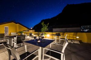 a rooftop patio with tables and chairs at night at Amalfi Luxury House in Amalfi