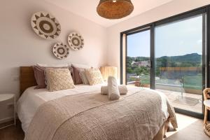 una camera da letto con un letto grande e una grande finestra di Bellezza - Villa climatisée piscine a Lecci Altre 15 foto
