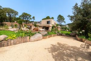 una casa con un cortile con un vialetto di ghiaia di Bellezza - Villa climatisée piscine a Lecci