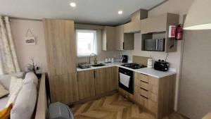 a small kitchen with a sink and a stove at Sandy Feet Retreat, West Sands in Selsey