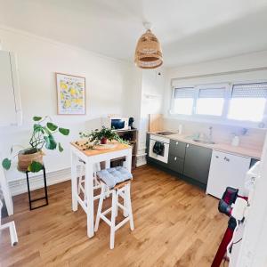 a kitchen with a white table and a white counter at zenitude in Marquette-lès-Lille