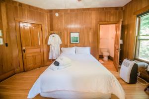 a bedroom with a large white bed and wooden walls at Jack Room BW Boutique Hotel in Central Lake