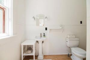 a white bathroom with a toilet and a sink at Mayson Room BW Boutique Hotel in Central Lake