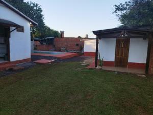 a backyard of a house with a door and a yard at DOÑA ROSA in Puerto Iguazú