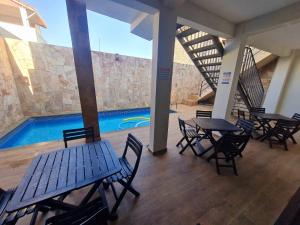 a patio with tables and chairs and a swimming pool at Recanto da lele in Aparecida