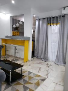 a living room with a table and a yellow counter at Rincon d Alicia 2 in Dakar