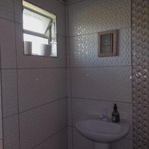 a white bathroom with a sink and a window at Pousada Serra Azul in Juquiá +72 photos