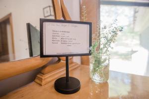 a sign on a stand on a table with a vase at Amelia Room BW Boutique Hotel in Central Lake