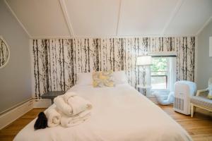 a bedroom with a bed with towels on it at Mahaney Suite BW Boutique Hotel in Central Lake