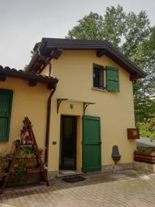 a house with green shutters and a door at Ca' Usignolo in San Ruffillo