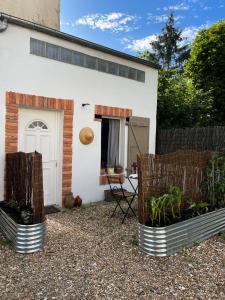 a white house with two plants in front of it at Tiny house 15min away from Opera Garnier in Argenteuil