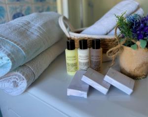 a table with three bottles of moisturizers and towels at NINFEA SEAVIEW APARTMENT - Elegant, Bright and Spacious, Steps from the Sea & Station in Nettuno