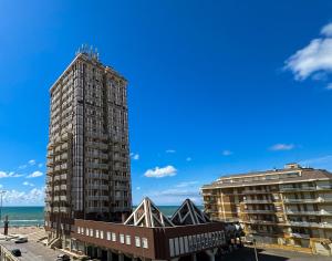 a tall building next to two buildings and the ocean at NINFEA SEAVIEW APARTMENT - Elegant, Bright and Spacious, Steps from the Sea & Station in Nettuno
