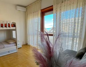 a bedroom with a large window with a view of the ocean at NINFEA SEAVIEW APARTMENT - Elegant, Bright and Spacious, Steps from the Sea & Station in Nettuno +15 photos